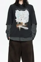 Camiseta de algodón negra, corte oversize, con cuello redondo. Presenta un estampado gráfico grande en el frente que incluye el texto "BIMBAYLOLA", dos lobos en una nube y un paisaje con relámpagos.