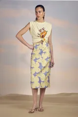 Falda midi de tiro alto, corte recto y estampado floral amarillo sobre fondo lila.