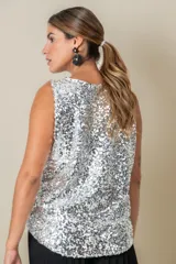 Blusa sin mangas confeccionada en tela cubierta de lentejuelas doradas y plateadas, con escote redondo y corte holgado.