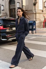 Jeans de tiro alto color azul oscuro, con cintura elástica en la espalda, bolsillos delanteros y bolsillos de plastrón en la espalda. Presenta pernera ancha y cierre frontal con cremallera y botón a presión.