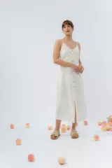 Vestido midi celeste de tejido tipo seda fría, con breteles finos regulables, botones de madera decorativos en el frente, pliegues decorativos en la cintura y cierre invisible en el costado.