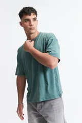 Remera de manga corta color verde con efecto lavado, corte boxy holgado con hombros caídos, escote redondo y logo bordado en el pecho.