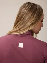 Remera de manga larga con cuello tortuga, confeccionada en tejido de algodón con elastano, de corte ajustado al cuerpo y diseño liso.