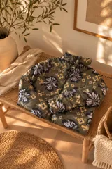 Campera puffer color verde militar con estampado floral grande y detalles geométricos, cuello alto y cierre frontal con cremallera.