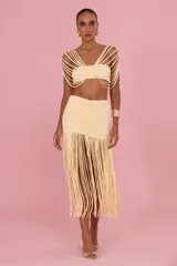 Falda larga negra de jersey, con diseño ajustado en la parte superior con fruncido central y caída de flecos largos en la parte inferior con tajo lateral.