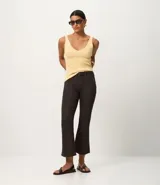 Blusa sin mangas de punto acanalado color crema, con escote en V y espalda descubierta. Confeccionada en una mezcla de viscosa y poliamida, presenta un ajuste al cuerpo y textura vertical en relieve.