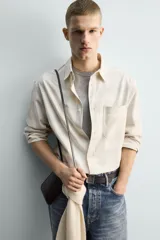 Camisa de corte relajado confeccionada en tejido de algodón con estampado de cuadros difuminados. Presenta cuello solapa, manga larga con puños abotonados, bolsillo de plastrón en el pecho y cierre frontal de botones.