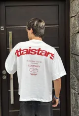 Remera celeste de corte holgado con estampado en rojo en la espalda con el texto "ittaistars", "European Tour by Ittai Stars Company" y el logo de la marca.