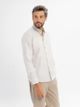 Camisa de manga larga con diseño de rayas finas, cuello con botones y bolsillo frontal. Presenta cierre de botonadura frontal y corte regular.