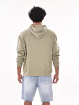 Buzo con capucha (canguro) color verde militar, corte holgado, con bolsillo canguro frontal y estampado gráfico en el pecho.