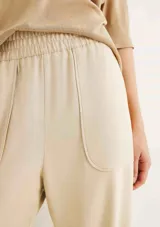 Pantalón color marrón, de corte carrot y cintura alta con elástico.