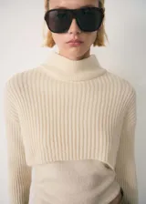 Jersey de punto de canalé en color crema, con cuello perkins y diseño combinado de estilo cropped.