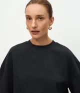 Blusa de algodón de corte oversized, color gris oscuro, con mangas cortas y cuello redondo.
