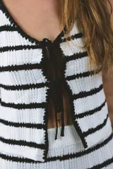 Chaleco tejido a rayas horizontales blancas y negras, con lazos delanteros.