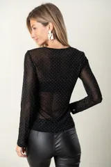 Remera de tul negra con apliques de brillos plateados y mangas largas.