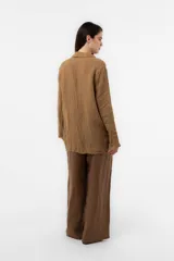 Pantalon de lino verde militar, de calce relajado y pierna amplia, con cintura elastizada, boton delantero y pinzas en el frente.