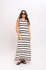 Vestido largo de punto con diseño de rayas en zigzag de color blanco y negro, sin mangas, con ribetes en tono bordó en el cuello y las sisas, y aberturas laterales en el bajo.