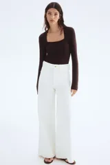 Top entallado en punto suave con escote cuadrado y mangas largas, color marrón oscuro.