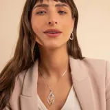 Collar de plata 925 con cadena fina tipo veneciana y un dije colgante de diseño geométrico en forma de ojo o hoja estilizada, compuesto por dos siluetas entrelazadas, una de ellas con detalles de brillo.