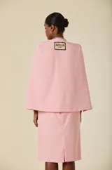Capa de mujer color rosa, con diseño de mangas abiertas tipo capa y silueta estructurada. Presenta un corte frontal abierto y una caída fluida y elegante.