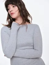 Remera de manga larga entallada en tejido pointelle, con escote bote y detalle de pequeño lazo central. Presenta un acabado con borde picot en el escote.