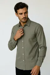 Camisa de algodón de manga larga con diseño de rayas verticales en tonos gris y blanco, cuello camisero clásico y cierre frontal con botones.