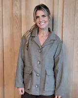 Sobrecamisa de paño con diseño de espiga, corte clásico de chaqueta, cuello solapa, cierre frontal con botones y dos bolsillos delanteros con solapa.