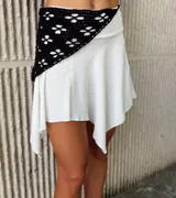 Mini pollera blanca de tela liviana con corte irregular y diseño con picos asimétricos.