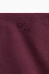 Top deportivo de manga larga con tecnología DryMove, corte ajustado y diseño cropped. Presenta escote en V con detalle girado en el frente y aberturas para el pulgar en los puños.