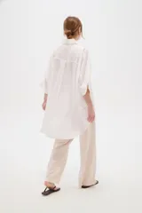 Camisa de lino blanca de corte holgado, con cuello camisero y mangas tres cuartos, diseñada con estilo casual.