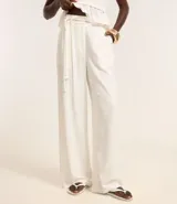 Pantalón wide leg de cintura alta, confeccionado en viscolino color blanco, con trabillas en la cintura, elástico atrás de la cintura, cierre tradicional, pliegues y cinturón de cuerda.