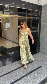 Vestido largo estampado con escote en V profundo y tirantes anchos. El diseño presenta un frunce o nudo en el centro del busto y tajos laterales en la falda.