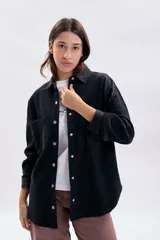 Sobrecamisa de pana en color gris oscuro, con cierre frontal de botones metálicos, cuello clásico y bolsillos frontales.