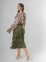 Camisa de seda italiana con diseño reversible, permitiendo usar el lazo en la parte frontal o posterior. Presenta un estampado sutil con motivos abstractos y animal print, cuello alto con volados, mangas largas con puños elásticos y corte holgado.