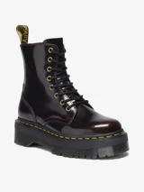 Borcego Dr. Martens modelo Jadon Arcadia, color bordó brillante con efecto desgastado que revela capas contrastantes. Presenta 8 ojales dorados, cordones negros, suela de plataforma de 4 cm con surcos laterales, tirador con logo AirWair y pespunte amarillo.