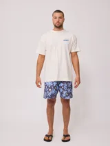 Short de baño Rusty con estampado de motivos botánicos y puntos amarillos sobre fondo azul. Cuenta con cintura elástica con cordón de ajuste y bolsillo lateral.