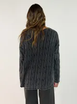 Sweater de punto con diseño de trenzas verticales, cuello redondo y corte holgado. Presenta un acabado texturizado con efecto lavado en color gris oscuro.