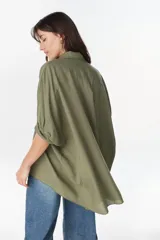 Camisa de manga larga color verde militar, con cuello camisero, cierre frontal con botones y diseño amplio.