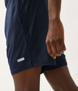 Bermuda deportiva masculina de la marca Get Over, confeccionada en tejido de poliéster con tecnología Dry Fit para una rápida evaporación del sudor. Presenta un diseño ligero con cintura elástica y una pequeña etiqueta aplicada en la parte inferior.