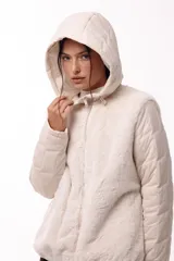 Campera con capucha, cuerpo de pelo sintético y mangas matelaseadas con cierre frontal.