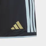Short de fútbol Adidas de la Selección Argentina, color azul oscuro con tres estrellas doradas y escudo de la AFA en dorado. Presenta tres franjas laterales en color celeste claro y ribetes celestes en los bordes.