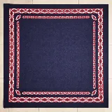Pañuelo de seda azul marino con diseño estampado de guardas geométricas en rojo y blanco en los bordes.