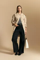 Trench azul marino de corte clásico con cuello amplio, botones frontales grandes en color beige, y detalles en los hombros.