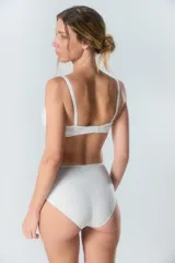 Bombacha tipo vedetina de tiro alto, confeccionada en tricot liso de color beige, con costuras reforzadas en los laterales.