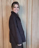Sobrecamisa de paño color beige, con cuello solapa, cierre frontal de botones y dos bolsillos delanteros con solapa.