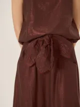 Faja regulable color marrón con detalles bordados en tono rojizo y terminaciones en forma de pétalos, diseñada para atar en la cintura.