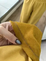 Conjunto de dos piezas compuesto por un buzo de cuello redondo y mangas largas con diseño reversible y un pantalón de corte ancho con cintura elástica.