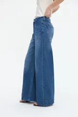 Jean wide leg azul de tiro alto, con corte amplio y costuras verticales decorativas en el frente.