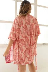 Bata de dormir corta color rosa con estampado de leopardos, con detalles de puntilla roja en el escote y en el frente.