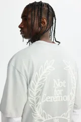 Remera de algodón en punto pesado, color verde menta, con cuello redondo acanalado, hombros caídos y diseño estampado en el pecho con la frase 'Not for Ceremony'.